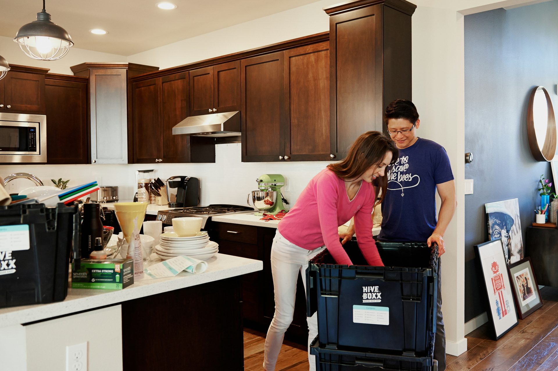 woman in pink long sleeve shirt standing beside kitchen sink
